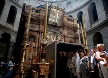 ภาพถ่ายเมื่อวันที่ 29 พฤษภาคม 2016 ขณะนักท่องเที่ยวต่อแถวเพื่อเข้าไปยังสุสานพระเยซูซึ่งมีโครงโลหะติดตั้งครอบบริเวณประตูทางเข้า ( AFP PHOTO / GALI TIBBON)