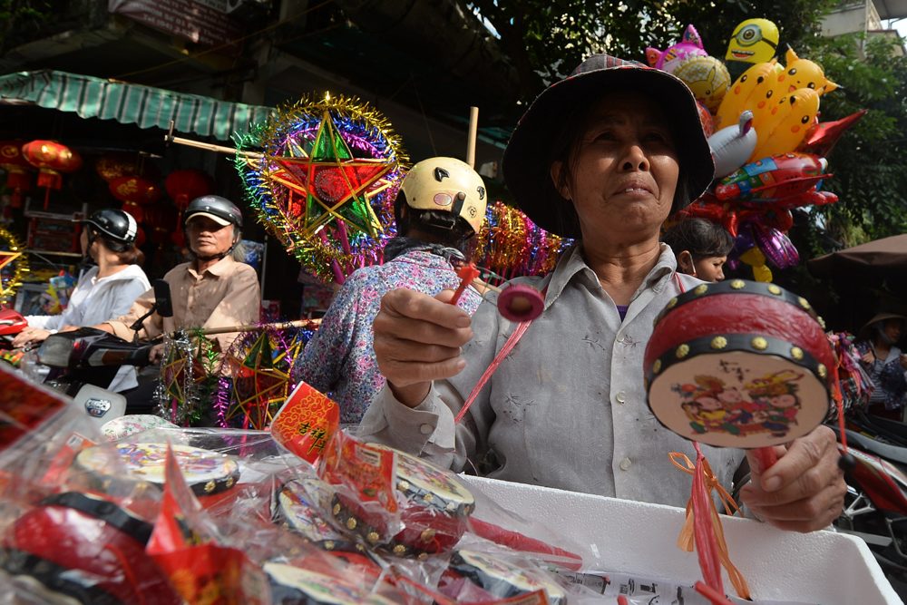 แม่ค้าแผงลอยชาวเวียดนามขายของเล่นในช่วงเทศกาลไหว้พระจันทร์ในกรุงฮานอย ภาพถ่ายเมื่อวันที่ 13 กันยายน 2016 (AFP PHOTO / HOANG DINH NAM) 