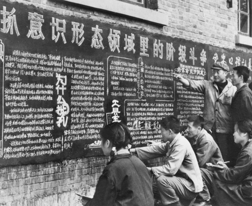 ภาพแรงงานจีนขณะอ่านกระดานประกาศซึ่งเขียนด้วยลายมือหรือ “ต้าจือเป้า” (Dazibao) เรื่องราวจำนวนมากมักประณามค่านิยมดั้งเดิมของชาวจีนที่ถูกมองว่าขัดต่อหลักสังคมนิยม ภาพถูกเผยแพร่เมื่อเดือนมีนาคม 1974 โดยสื่อจีน (AFP PHOTO / XINHUA)